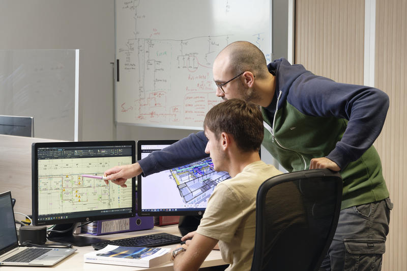 Photo de deux personnes dans un bureau travaillant sur un ordinateur.
